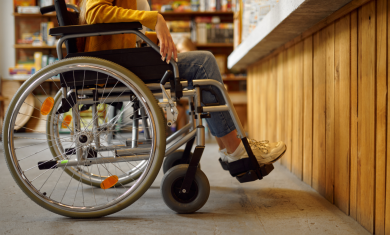 Mulher em cadeira de rodas sendo atendida com prioridade em um restaurante, exemplificando a prática de atendimento preferencial e acessibilidade no setor de alimentação.